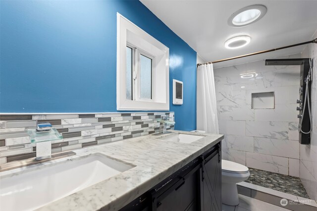 bathroom featuring toilet, vanity, and a shower with shower curtain