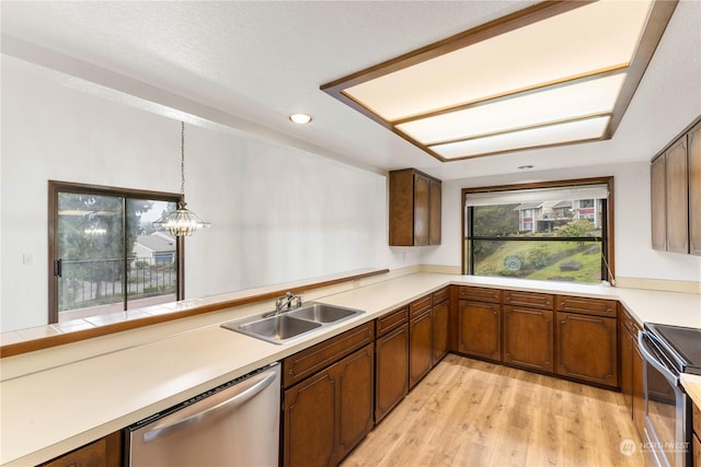 kitchen featuring pendant lighting, an inviting chandelier, sink, light wood-type flooring, and stainless steel appliances