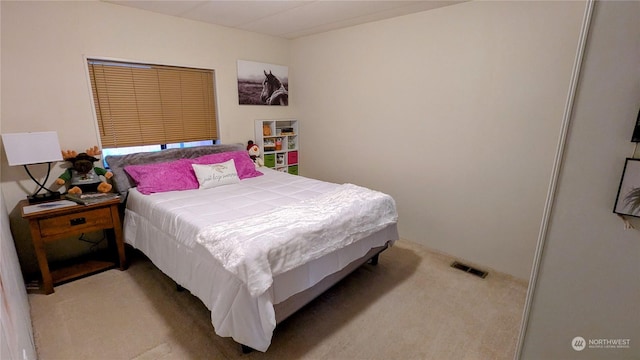 bedroom featuring visible vents and light colored carpet