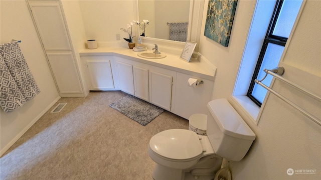 bathroom with baseboards, visible vents, vanity, and toilet