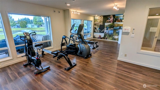 workout area featuring dark wood finished floors and baseboards