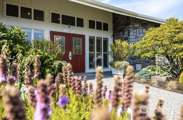 doorway to property featuring a garage and stone siding