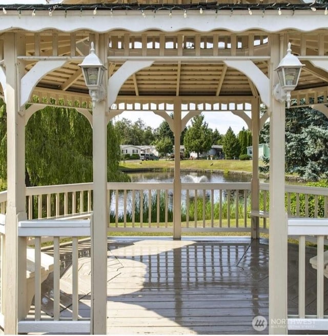 wooden terrace with a water view and a gazebo