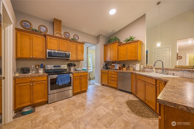 kitchen featuring sink, stainless steel appliances, kitchen peninsula, lofted ceiling, and decorative light fixtures