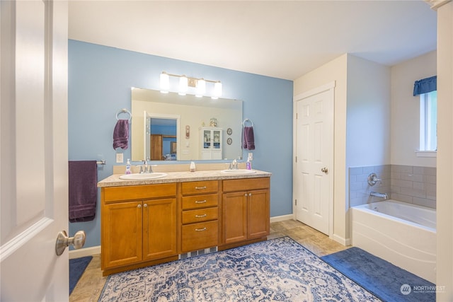 bathroom featuring tile patterned flooring, vanity, and a washtub