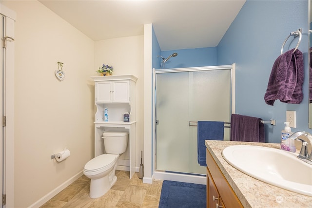 bathroom featuring vanity, a shower with door, and toilet