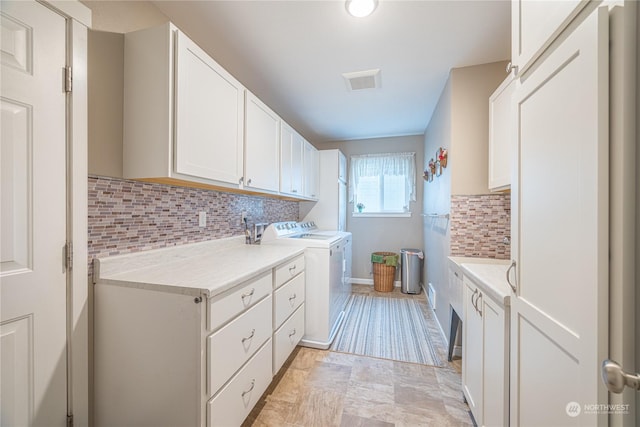 laundry area with washer and clothes dryer and cabinets