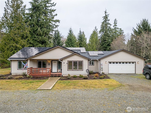 166 Nelson Creek Ln, Port Angeles, WA 98363 - ranch-style house with an attached garage, solar panels, a front yard, a porch, and gravel driveway