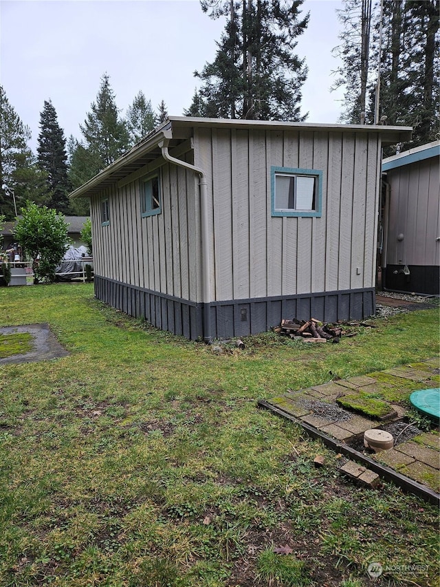 view of home's exterior featuring a lawn and an outdoor structure