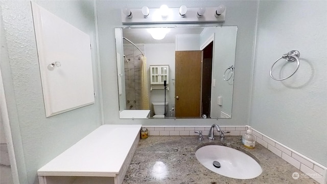 bathroom featuring toilet, vanity, and walk in shower