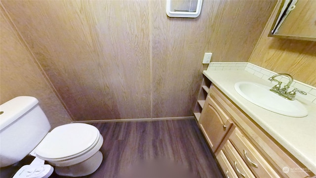 bathroom with toilet, vanity, and hardwood / wood-style floors