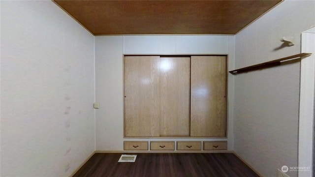 unfurnished bedroom with a closet and dark hardwood / wood-style floors