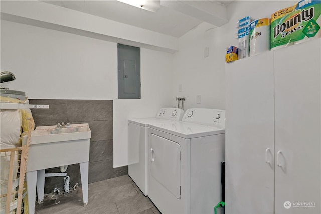 clothes washing area with washer and dryer, tile walls, and electric panel