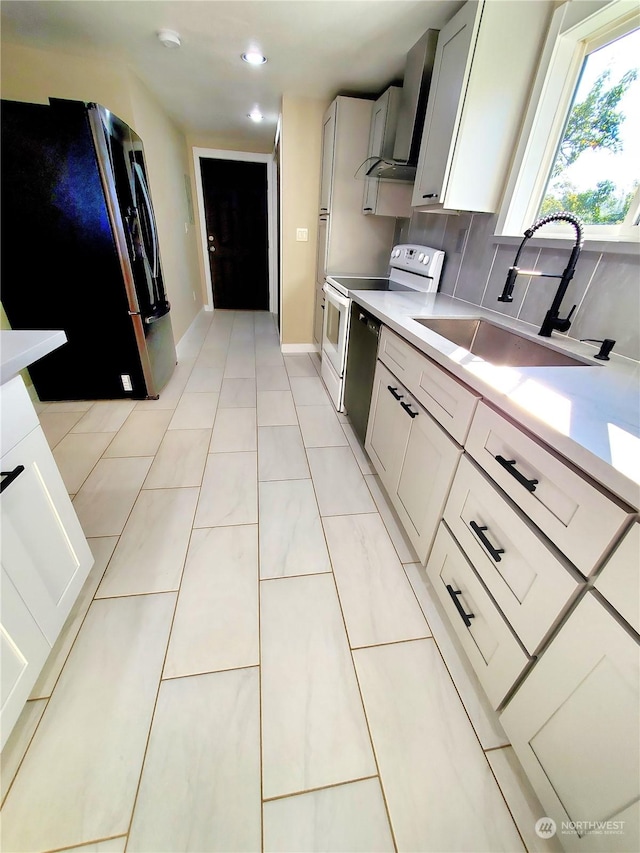 kitchen with sink, tasteful backsplash, white range with electric cooktop, stainless steel fridge, and exhaust hood