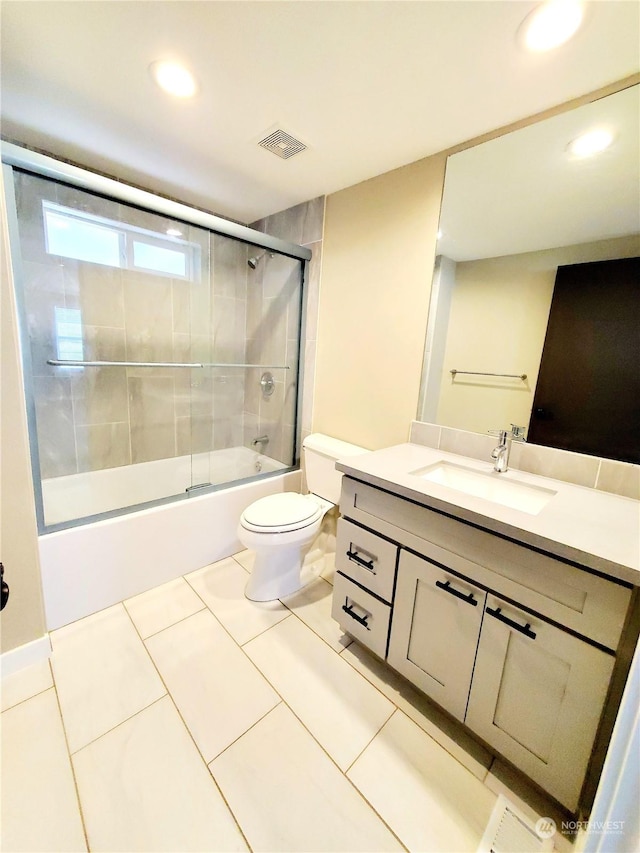 full bathroom featuring combined bath / shower with glass door, vanity, toilet, and tile patterned flooring