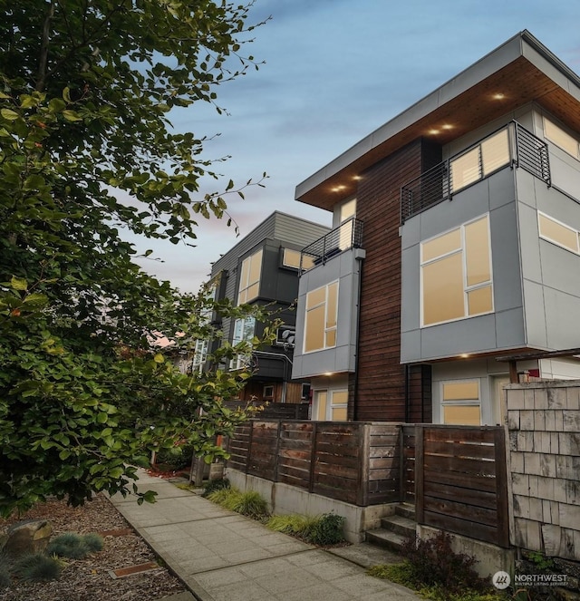 property exterior at dusk with a balcony