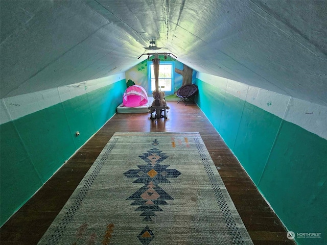 additional living space with vaulted ceiling and hardwood / wood-style flooring