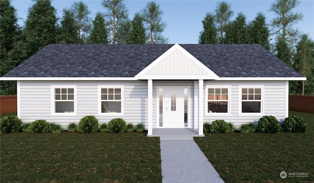 ranch-style home featuring a shingled roof, a front yard, and fence