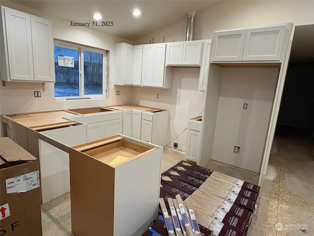 kitchen featuring lofted ceiling, cooktop, and white cabinets