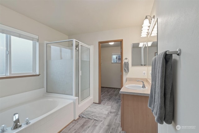 bathroom with vanity, wood-type flooring, and shower with separate bathtub