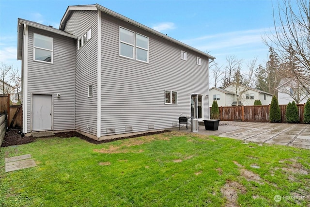 back of property with a lawn and a patio area