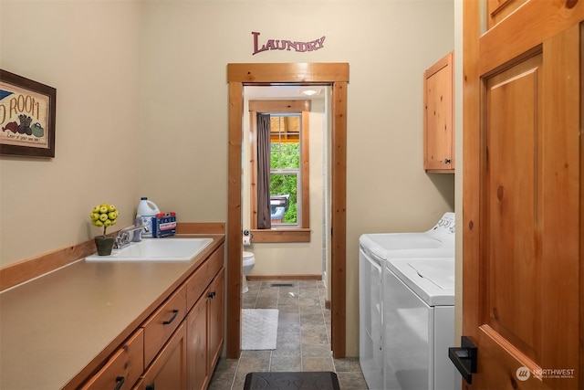 laundry room with sink, cabinets, and washing machine and clothes dryer