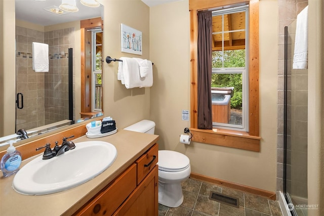 bathroom featuring an enclosed shower, vanity, and toilet