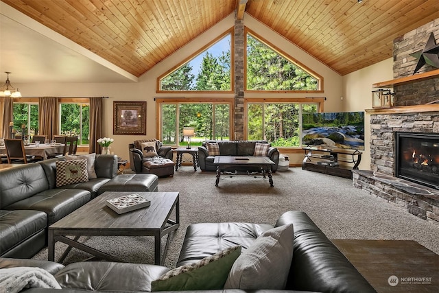 living room featuring wood ceiling, a stone fireplace, carpet, a notable chandelier, and high vaulted ceiling