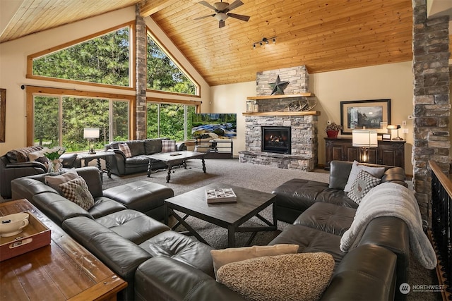 carpeted living room with high vaulted ceiling, wood ceiling, and a stone fireplace