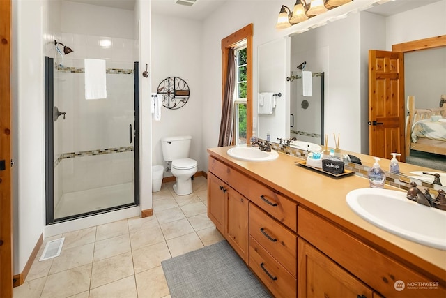 bathroom featuring toilet, tile patterned flooring, a shower with shower door, and vanity