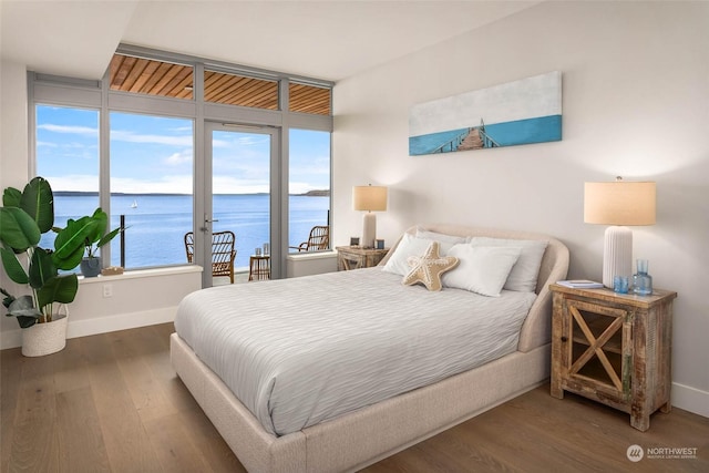 1250 Alki Ave SW Unit 3B, Seattle, WA 98116 - bedroom with a water view, wood finished floors, and access to outside