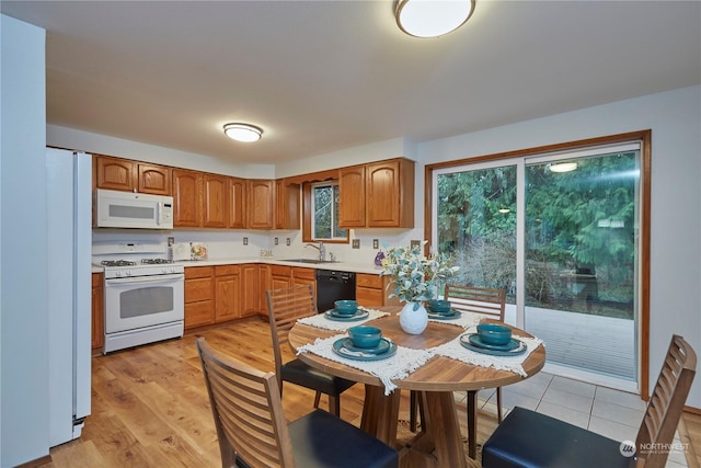 kitchen with sink, light hardwood / wood-style floors, and white appliances