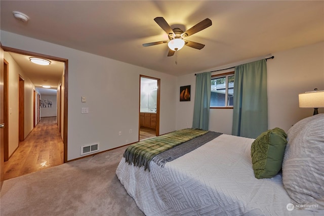 carpeted bedroom with ceiling fan and ensuite bathroom