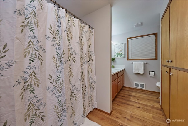 bathroom with hardwood / wood-style flooring, vanity, and toilet