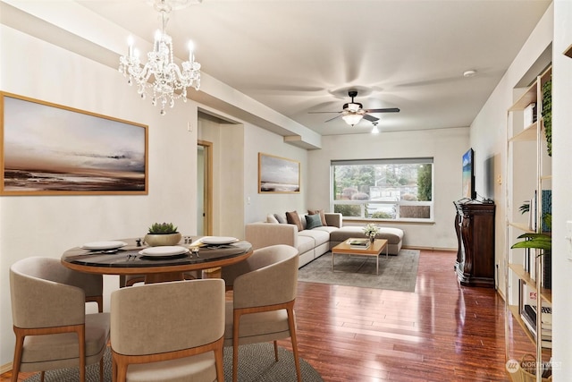 dining room featuring ceiling fan with notable chandelier and dark hardwood / wood-style floors