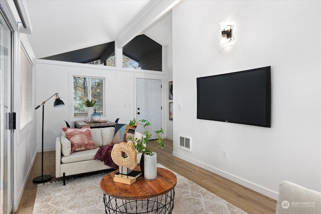 interior space with hardwood / wood-style flooring and lofted ceiling with beams