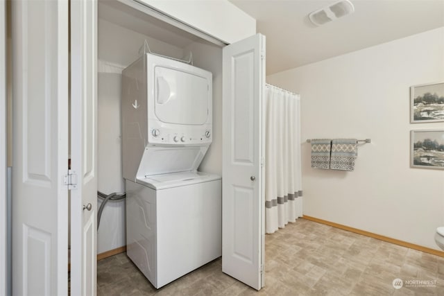 clothes washing area featuring stacked washing maching and dryer