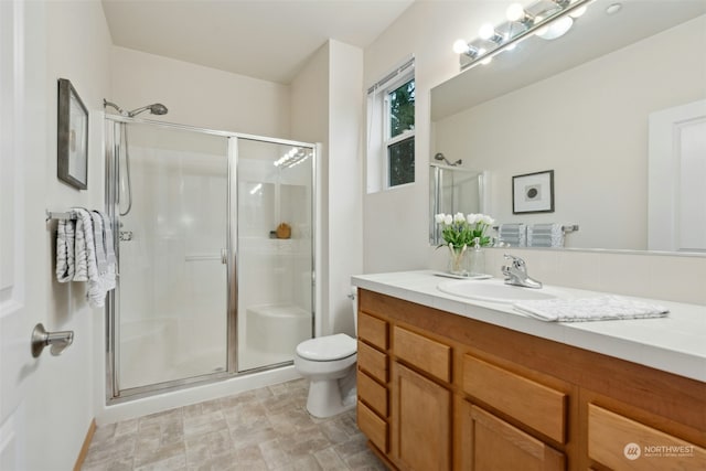 bathroom featuring vanity, toilet, and walk in shower