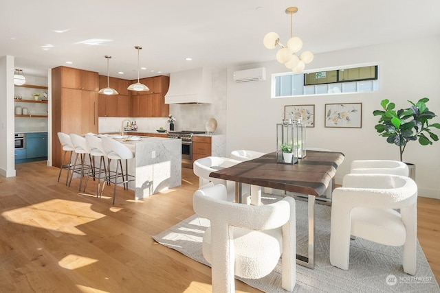 dining area featuring light hardwood / wood-style floors, sink, and a wall unit AC