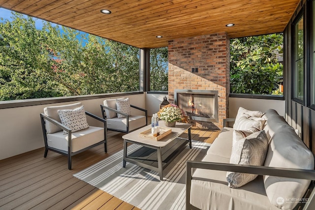 wooden deck with an outdoor living space with a fireplace