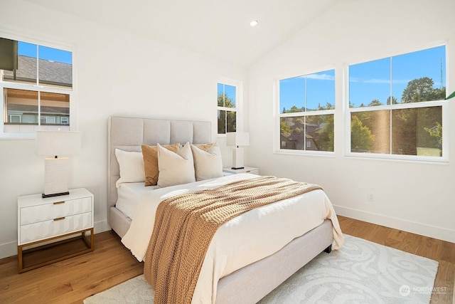 bedroom featuring hardwood / wood-style floors and vaulted ceiling