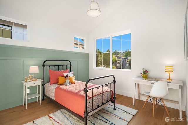 bedroom featuring high vaulted ceiling and hardwood / wood-style flooring