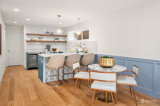 interior space with sink, beverage cooler, and light hardwood / wood-style floors