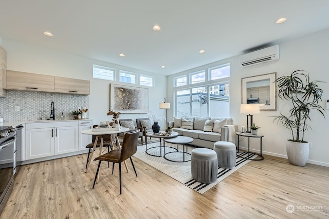 living room featuring light hardwood / wood-style floors, sink, and a wall mounted AC