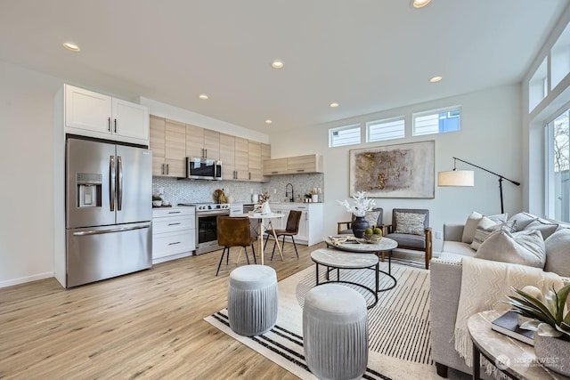 living room with light wood-type flooring and sink