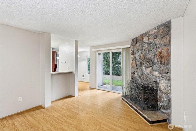 living room with a fireplace, wood-type flooring, and a textured ceiling