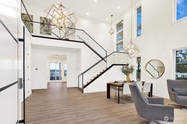 foyer featuring a chandelier, wood-type flooring, and a high ceiling