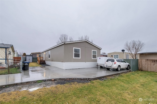 rear view of property with a lawn and a patio