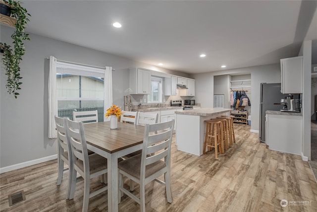 dining room with light hardwood / wood-style floors and sink