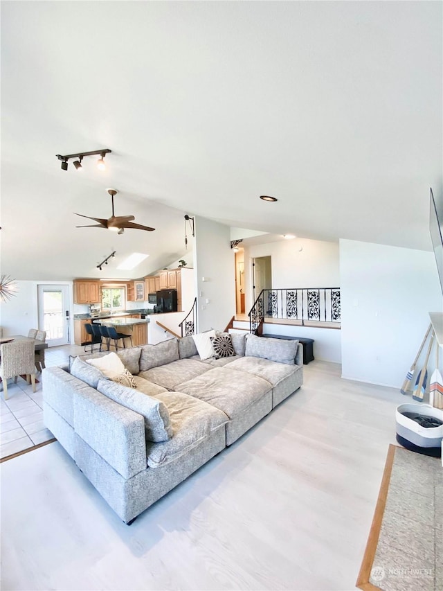 living room featuring ceiling fan and vaulted ceiling